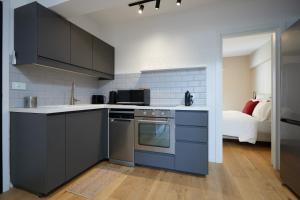 a kitchen with a stove top oven next to a bed at Incanto Boutique Suites - Koukaki in Athens