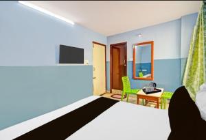 Habitación con cama, TV y escritorio. en MOONLIGHT Inn, en Hyderabad