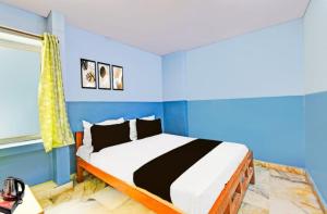Un dormitorio con una cama con paredes azules. en MOONLIGHT Inn, en Hyderabad 3 fotos más