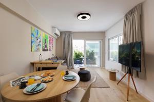 a living room with a wooden table and a large window at Incanto Boutique Suites - Koukaki in Athens