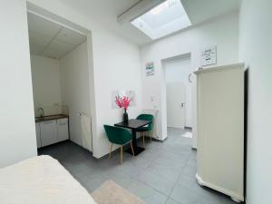 a room with a table and two chairs and a kitchen at Sonnenblume Residenz in Oftersheim