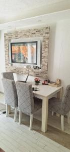 a desk with chairs and a television on a wall at Apartman Archy in Sarajevo
