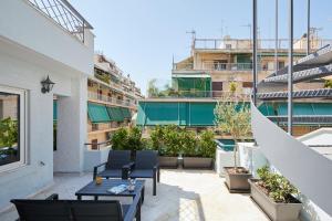 a rooftop patio with chairs and tables on a building at Incanto Boutique Suites - Koukaki in Athens