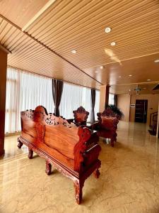 a lobby with two wooden benches in a building at khách sạn ANNA in Pleiku