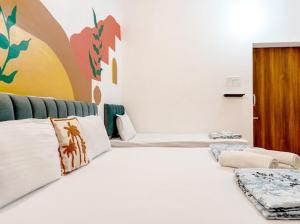 a bedroom with a large white bed with pillows at Raahee Homestay in Varanasi