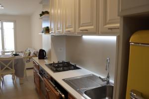 eine Küche mit Herd oberer Ofen neben einer Spüle in der Unterkunft Casa Maria in Santa Cesarea Terme