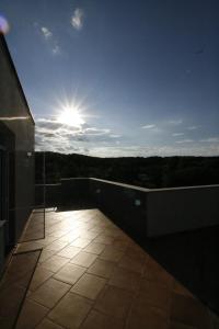 a balcony of a building with the sun in the sky at Hotel Marant in Sozopol