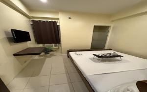 a room with a bed and a table in it at San Antonio's Place Suites in Manila