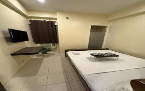 a small room with a bed and a table at San Antonio's Place Suites in Manila