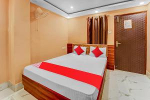 TapovanにあるHotel O Bhagirathi Palaceのベッドルーム1室(赤い枕のベッド1台付)