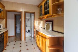 eine Küche mit Holzschränken und einer Waschmaschine in der Unterkunft Hermanos Pinzón in Zamora