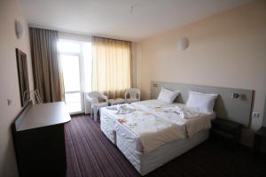 a hotel room with a large bed and a window at Hotel Marant in Sozopol