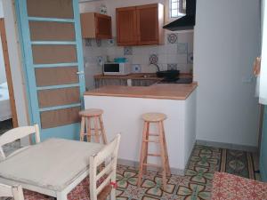 a small kitchen with a counter and two stools at Deli casa vacanze in Favignana