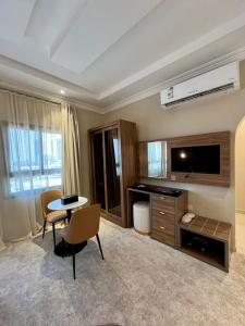 a living room with a television and a table and chairs at LAVANTA Hotel in Al Khobar +52 photos
