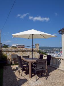 a table and chairs with an umbrella on a patio at Chancelas b in Combarro