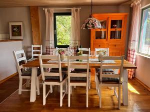 a dining room with a white table and chairs at Waldhaus im Erzgebirge in Augustusburg +13 photos