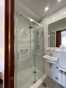 a bathroom with a glass shower and a sink at Hotel Capital de Galicia in Santiago de Compostela