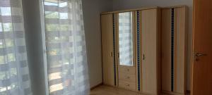 a bedroom with a dresser and a window with curtains at FeWo Eleni in Neuhof