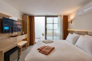 a bedroom with a large bed with a tv on the wall at Zenoa Alaçatı in Alaçatı