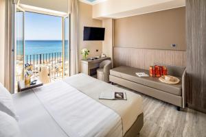 a hotel room with a bed and a view of the ocean at Hotel Albatros Varigotti in Varigotti
