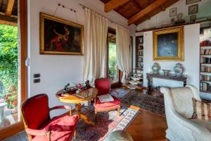 a living room with chairs and a table and a fireplace at Villa DAutore in Alba