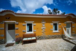 a yellow house with a bench in front of it at Sparrow Sintra Nest in Sintra