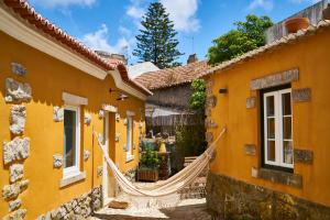 uma propriedade com uma rede de descanso entre dois edifícios em Sparrow Sintra Nest em Sintra