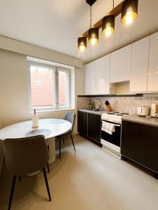 a kitchen with a table and a table and chairs at Kotimaailma Aparthotel Ankkuri - 4 Bedroom in Kotka