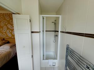 a small bathroom with a shower and a bed at The Coach House in Otterburn +68 photos