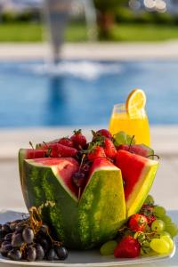 a plate of fruit with a slice of watermelon and berries at Hotel Lejla in Ulcinj