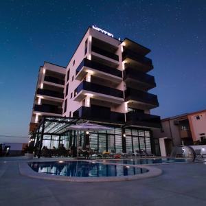 a building with a swimming pool at night at Hotel Lejla in Ulcinj