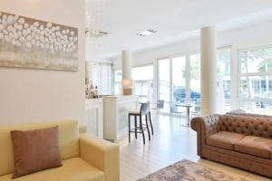 a living room with a couch and a kitchen at Hotel Fiamma & SPA Cesenatico in Cesenatico