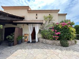 a house with pink flowers in front of it at le lodge Saint Clair in Sète