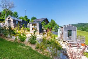 a group of houses in a field with a yard at Tiny house Kapha in Les Alliés