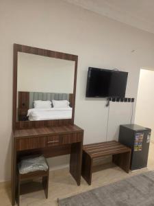 a bedroom with a mirror and a bed and a tv at منازل بريدة للشقق المفروشة in Buraydah