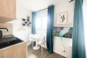 Una pequeña cocina con una mesa y una ventana. en Les studios de l'Albatros, en Saint-Nazaire 33 fotos más