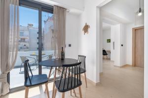 a dining room with a table and chairs and a window at Athens Meli in Athens