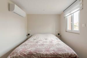 a bedroom with a bed in a room with a window at Appartement 6 personnes proche strasbourg avec parking in La Wantzenau