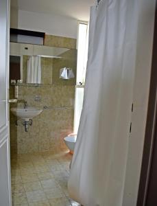a bathroom with a sink and a shower curtain at Hotel Adriatic in Omišalj