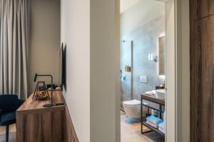 ein Badezimmer mit Waschbecken und Toilette in einem Zimmer in der Unterkunft Monumenti Heritage Hotel&Resort in Pula + 65 Fotos