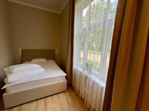 a bedroom with a bed and a large window at RUMIDO Station in Valmiera