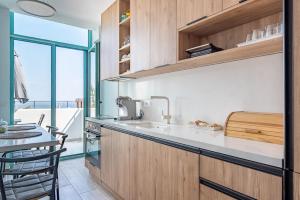 a kitchen with a sink and a counter with a table at Santorini Wave Loft 2 in Gjilek +33 photos