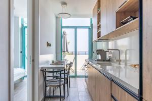 a kitchen with a counter with chairs and a table at Santorini Wave Loft 2 in Gjilek