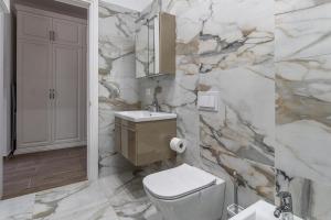 a marble bathroom with a toilet and a sink at Santorini Wave Loft 2 in Gjilek
