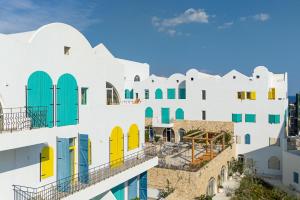 a group of white buildings with colorful doors and windows at Santorini Wave Loft 2 in Gjilek