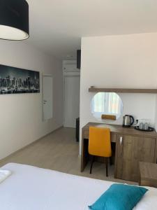 a bedroom with a desk and a yellow chair at REZEVICI BOUTIQUE VILLA in Petrovac na Moru