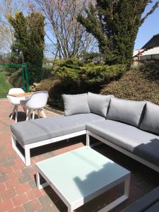 a couch and a coffee table on a brick patio at Le Clos Sigebert in Libramont