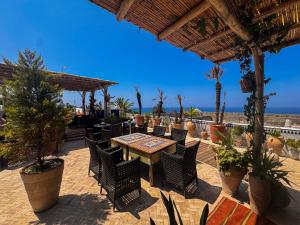 a patio with a table and chairs and palm trees at Riad Al-Qurtubi in Tangier