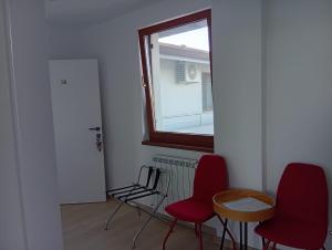 a room with two red chairs and a window at Techirghiol Boutique in Techirghiol