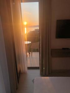 a room with a window with a view of the sunset at REZEVICI BOUTIQUE VILLA in Petrovac na Moru